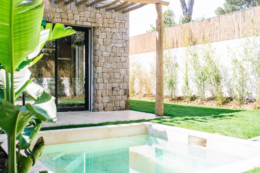 een zwembad in een achtertuin met een stenen huis bij Villa Alemagou in La Croix-Valmer