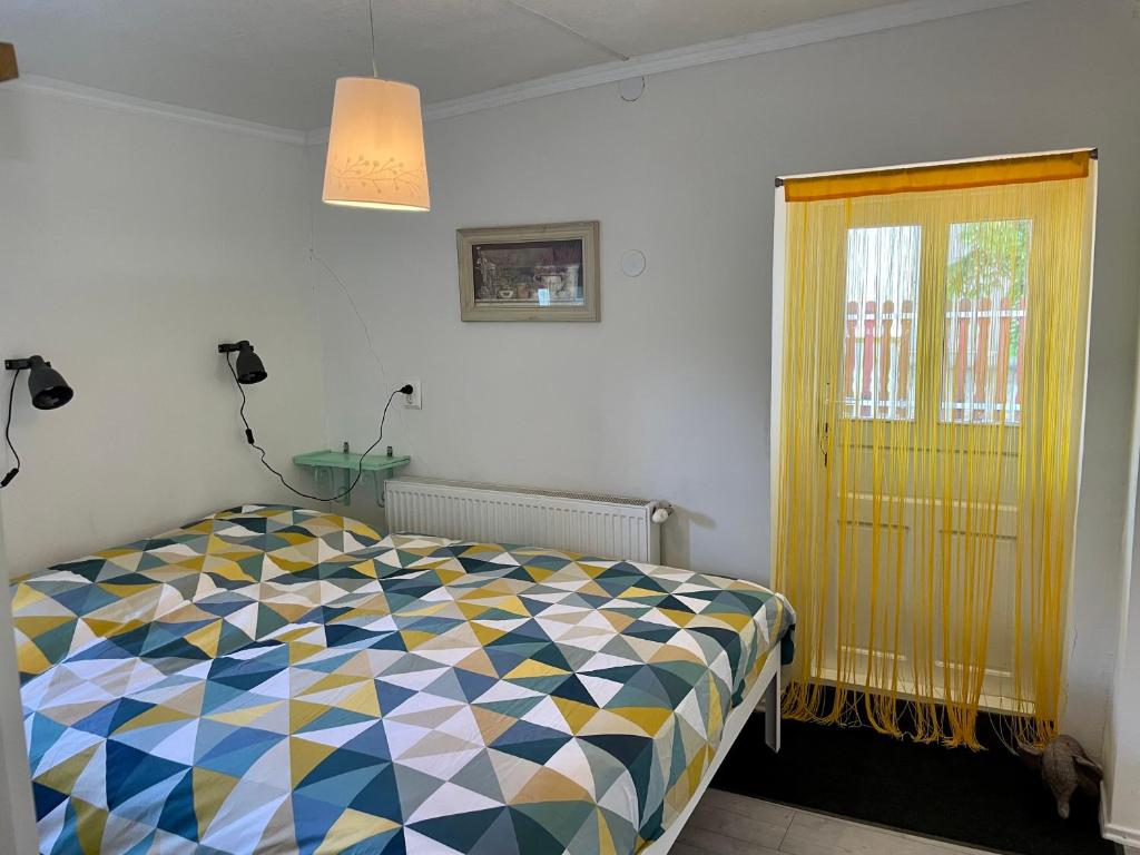 a bedroom with a colorful bed and a window at nyaraló emberi 