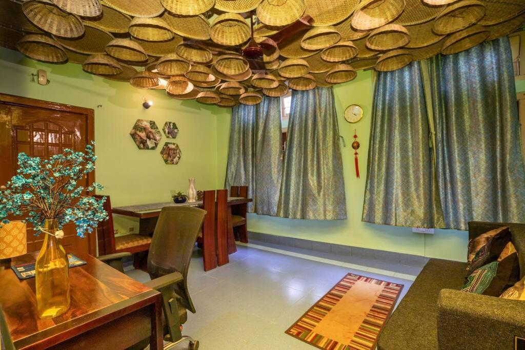 un soggiorno con tavolo, sedie e tende di BimBan's- A cozy little place a Guwahati
