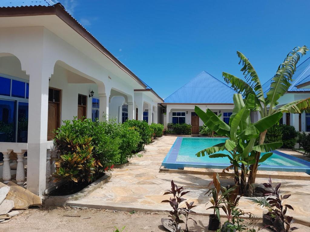 a villa with a swimming pool next to a building at Serenity 2 - Jambiani in Jambiani