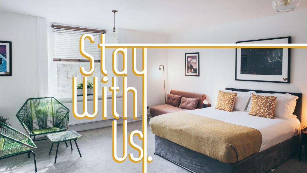 a bedroom with a bed and a chair and a sign that reads slow hotel at Caffeine&Machine in Stratford-upon-Avon