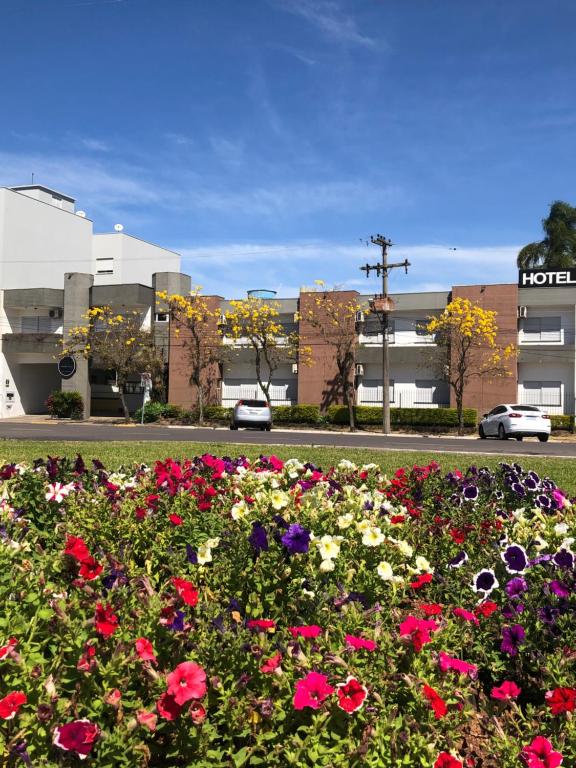 a field of flowers in front of a building at Tobaccos Palace Hotel in Santa Cruz do Sul