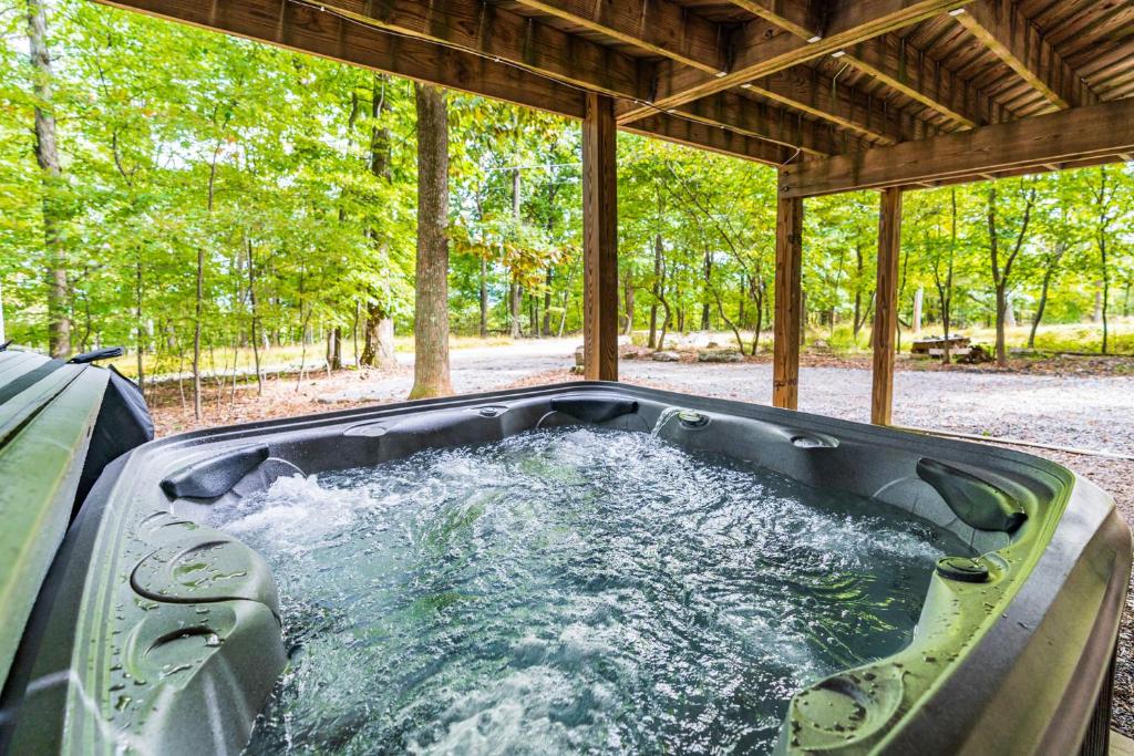 a hot tub in the middle of a backyard at Modern w Fire Pit Deck, Grill & Hot Tub in Berkeley Springs
