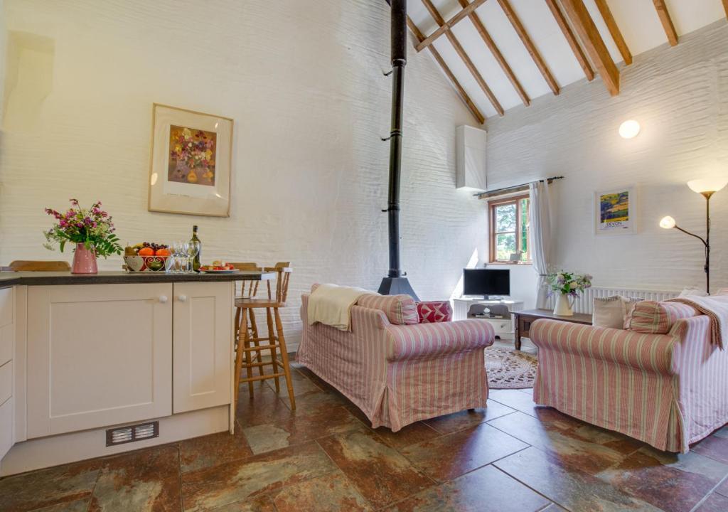 a living room with two chairs and a stove at Mill Cottage in Parracombe