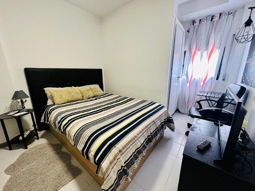 a bedroom with a bed and a television in it at Habitación in Madrid