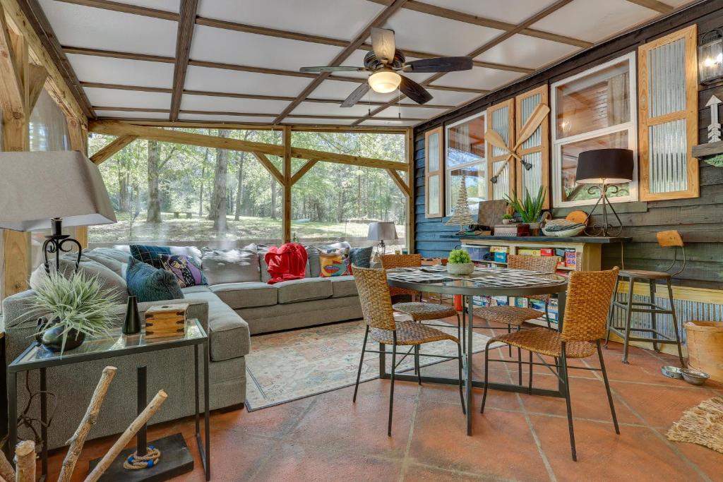 - un salon avec un canapé, une table et des chaises dans l'établissement Pet-Friendly Haleyville Cabin Rental with Kayaks!, à Haleyville