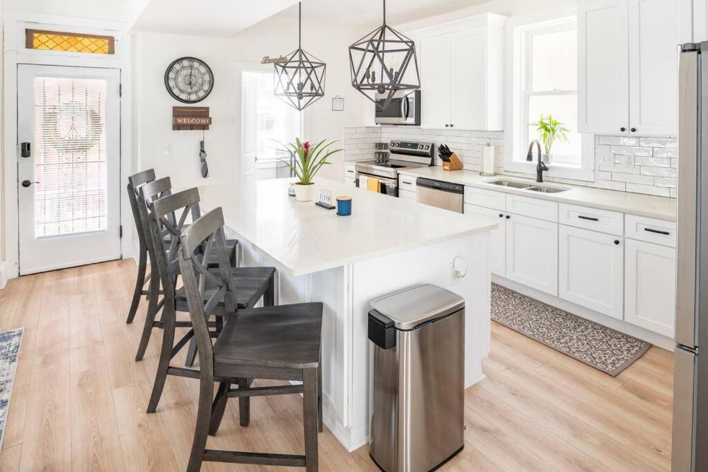 a white kitchen with a large white island with chairs at Entire Home in Newport in Newport