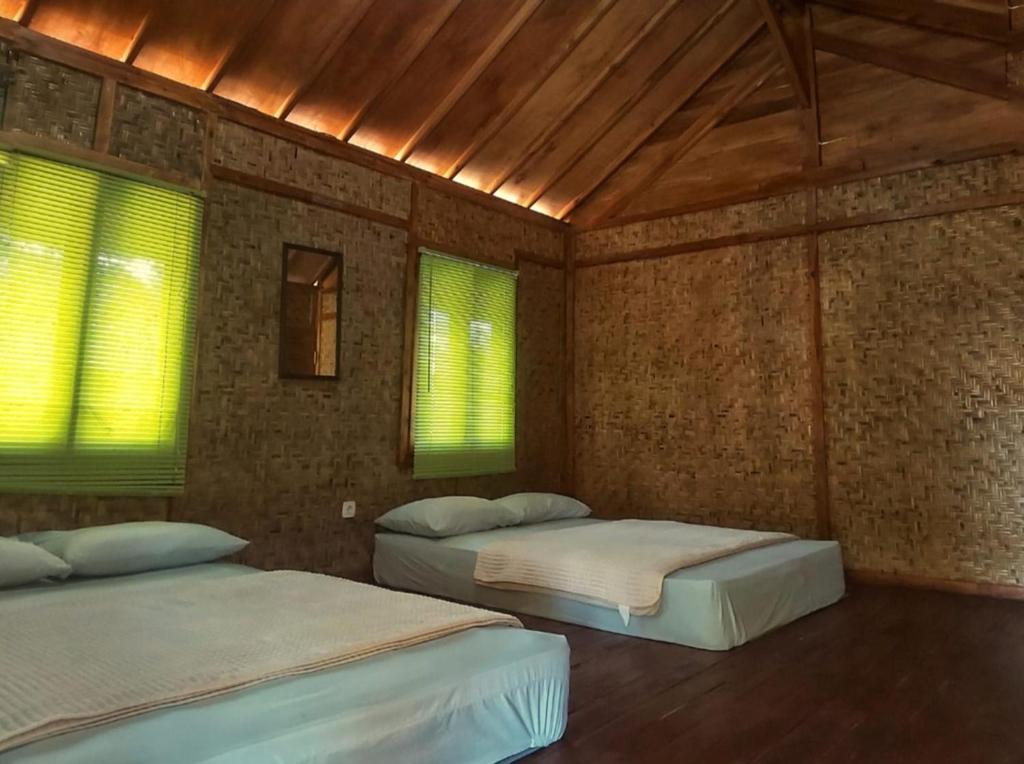 2 camas en una habitación con 2 ventanas en Zabu camp, en Selong