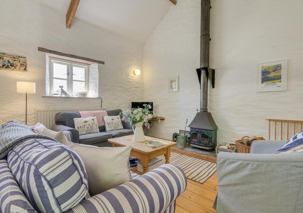 a living room with a couch and a fireplace at Mole Cottage in Parracombe