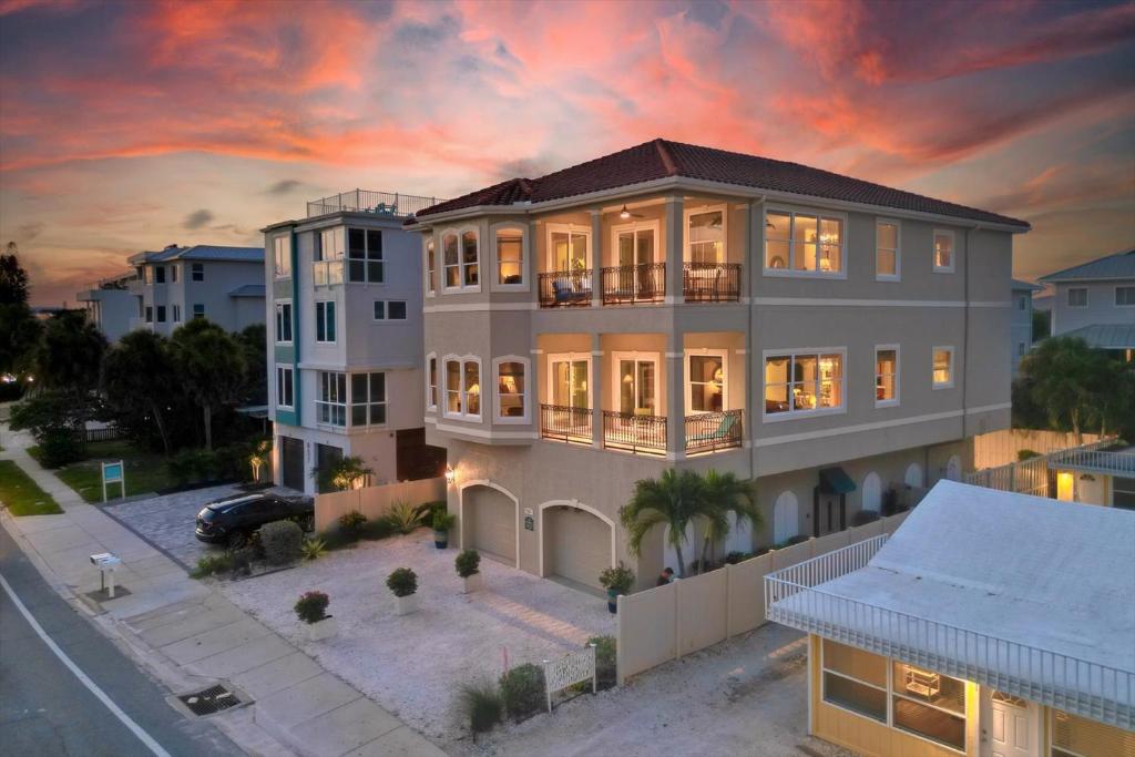 a large house with a sunset in the background at Ocean Vue By Beachside Management in Siesta Key