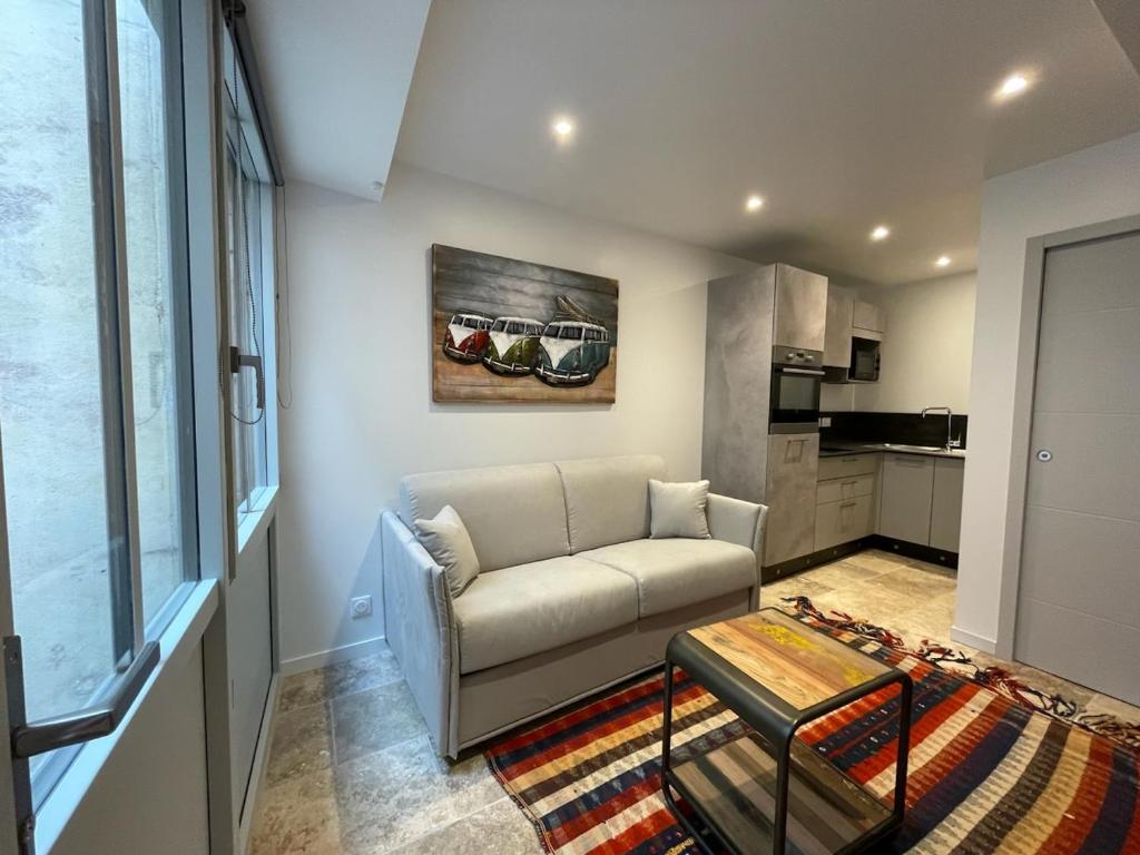 un salon avec un canapé et une table dans l'établissement Le St Louis 2 Joli Studio sur cour, à La Rochelle