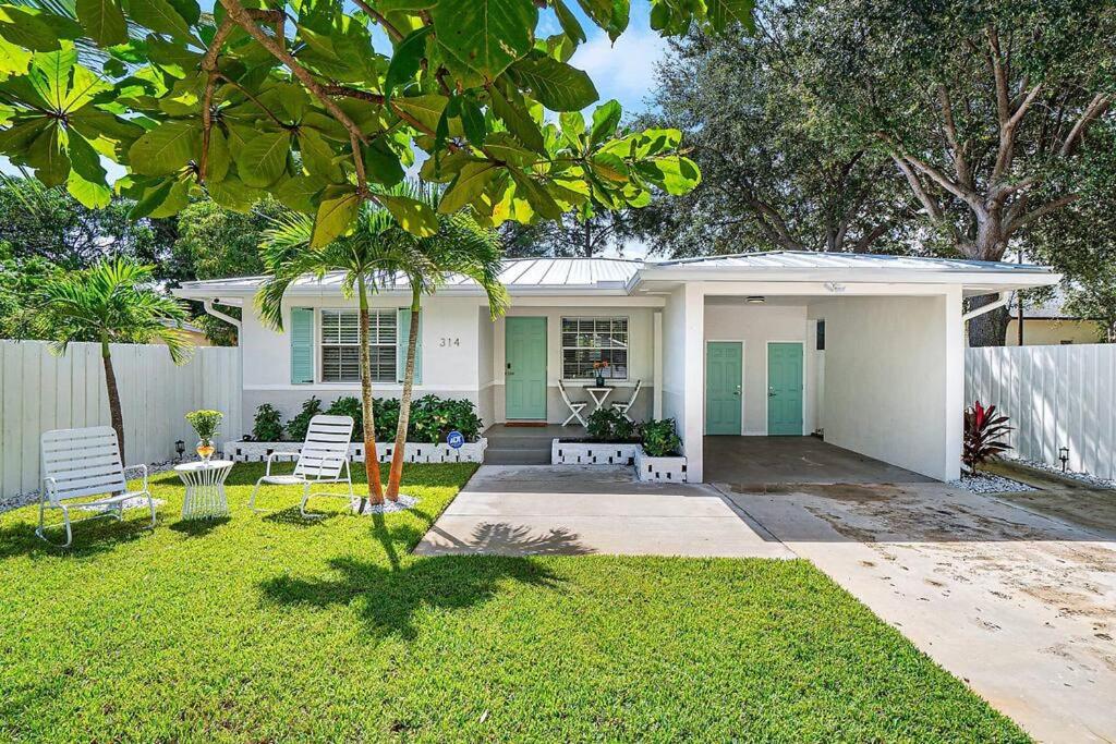 a white house with two chairs and a yard at Casita Delray in Delray Beach