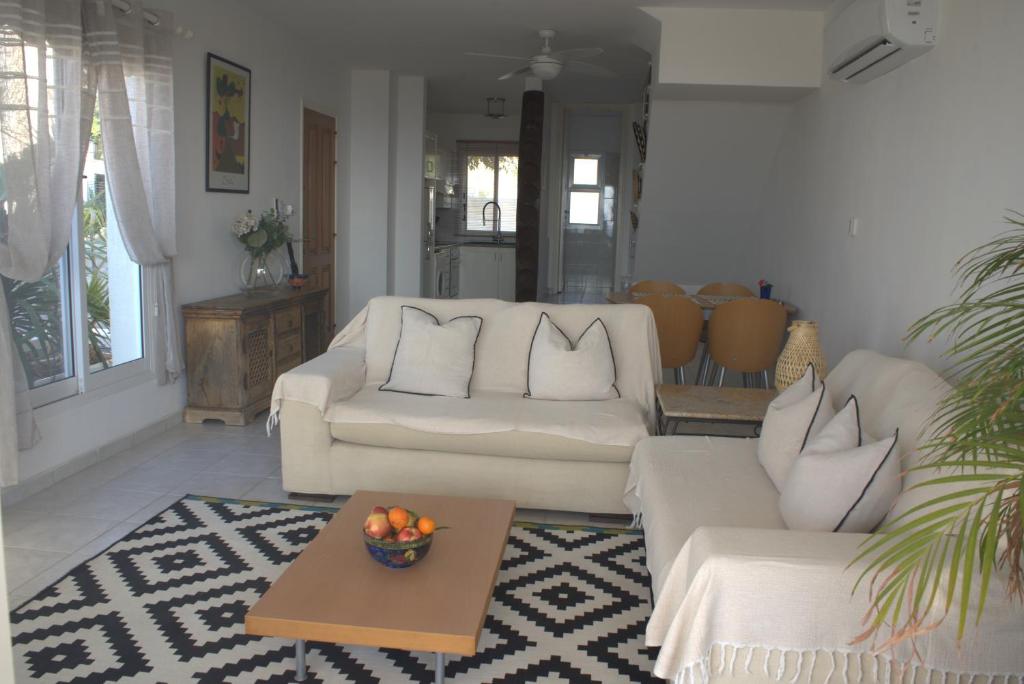 uma sala de estar com dois sofás brancos e uma mesa em Ocean Wings Panoramic SeaView em Kissonerga