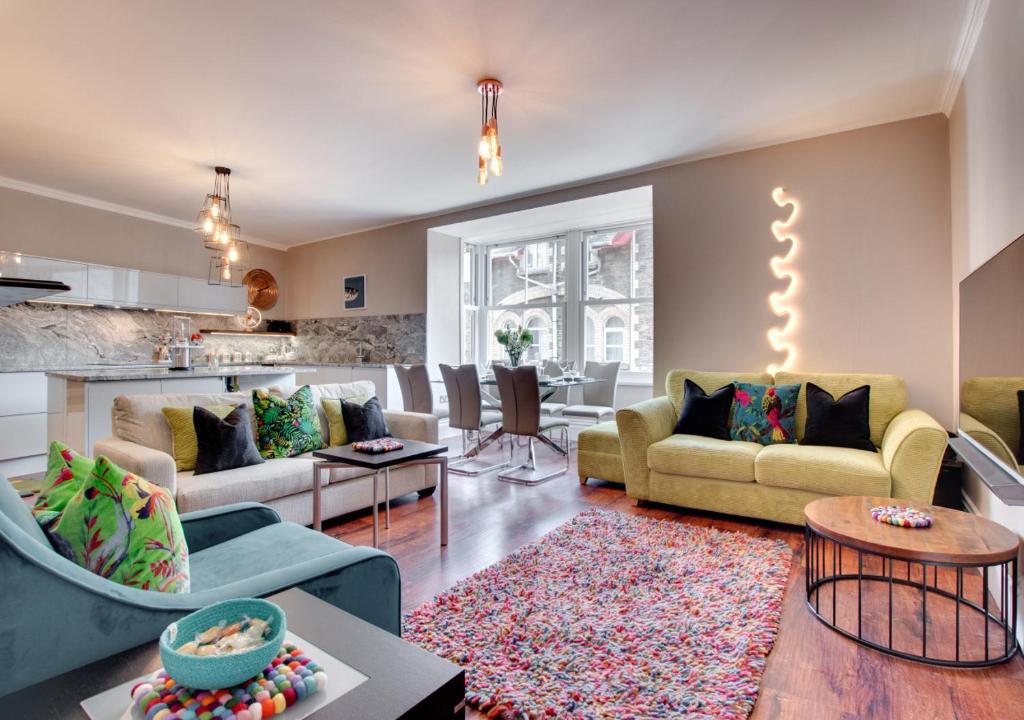 a living room with two couches and a kitchen at The Oriel in Lynmouth