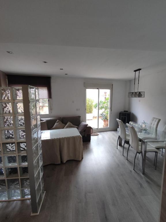 ein Wohnzimmer mit einem Sofa und einem Tisch mit Stühlen in der Unterkunft Apartamento luminoso con jardín in La Zubia