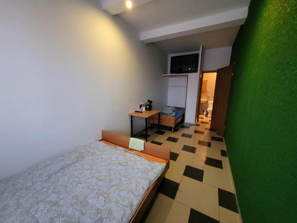 ein Schlafzimmer mit einem Bett und einer grünen Wand in der Unterkunft GuestHouse in Piaseczno