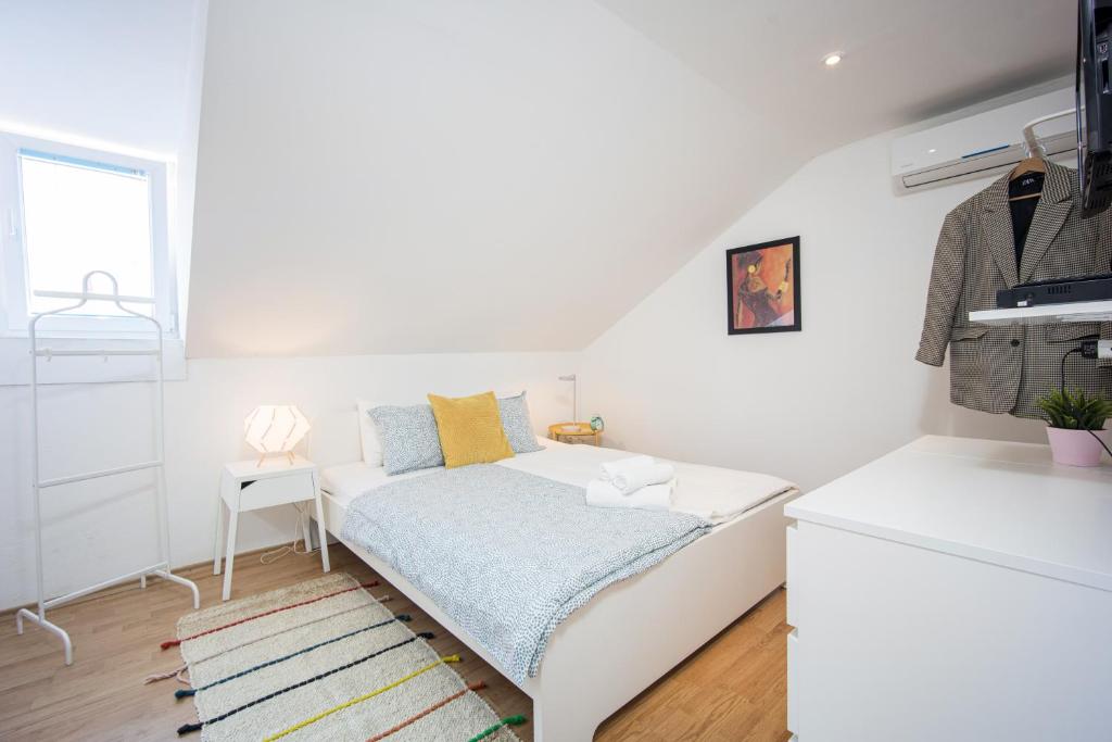 Cette petite chambre blanche dispose d'un lit et d'une cuisine. dans l'établissement Top-Floor Apartment in Trogir Center, à Trogir