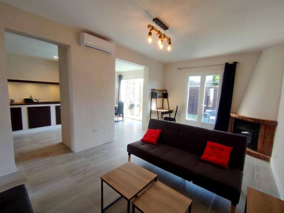 uma sala de estar com um sofá preto e almofadas vermelhas em La Villa Beata em Orange