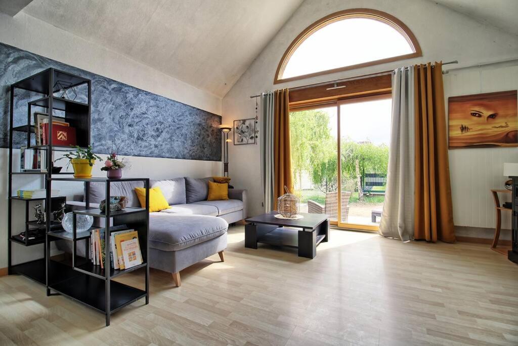 een woonkamer met een bank en een groot raam bij Maison Le Vignoble avec jardin - 6 personnes in Ribeauvillé