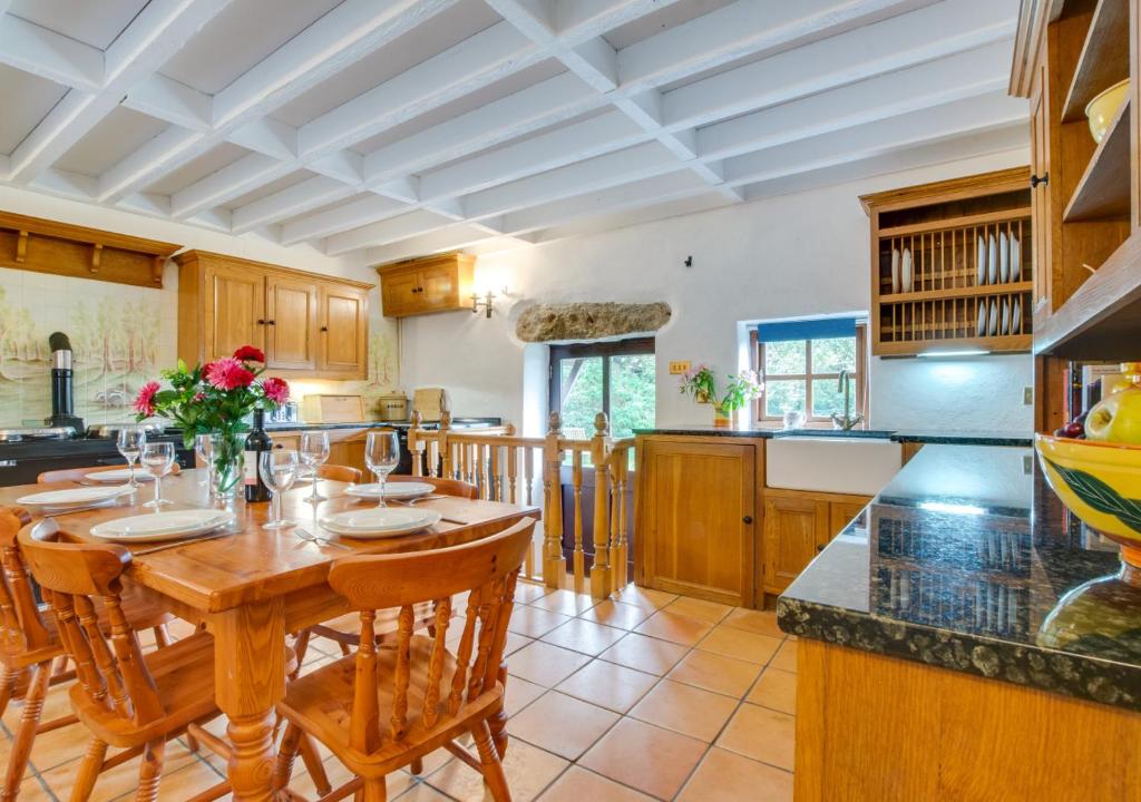 a large kitchen with a wooden table and chairs at The Granary in Porthcurno