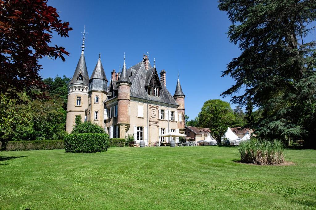 un vecchio castello con un prato davanti di Camping et Hotel Château du Haget a Montesquiou