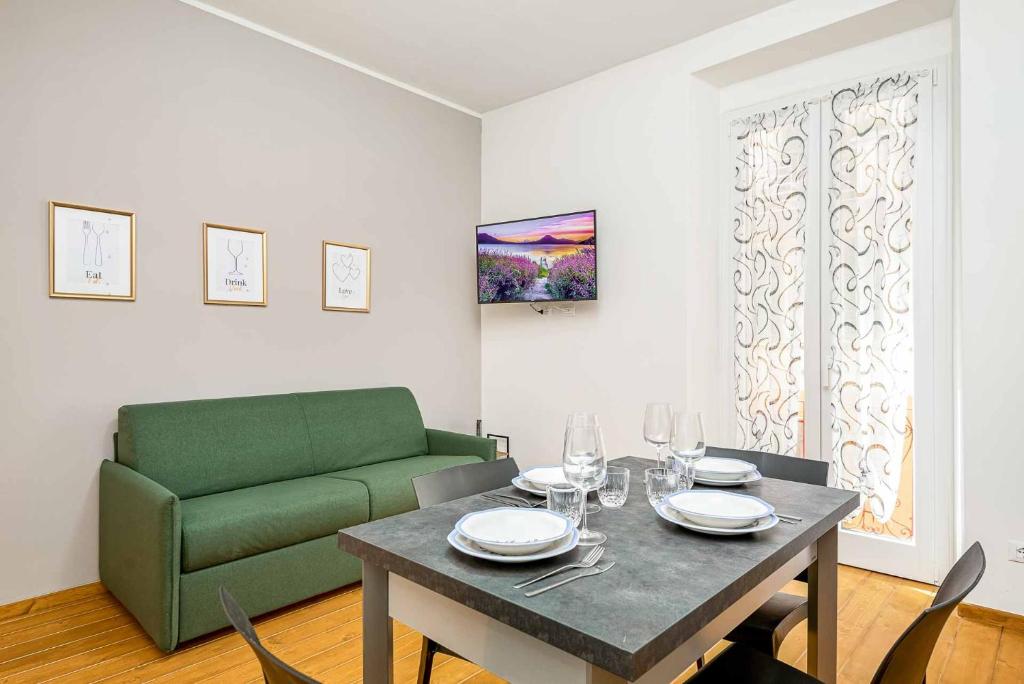 a living room with a table and a green couch at Yellove in La Spezia