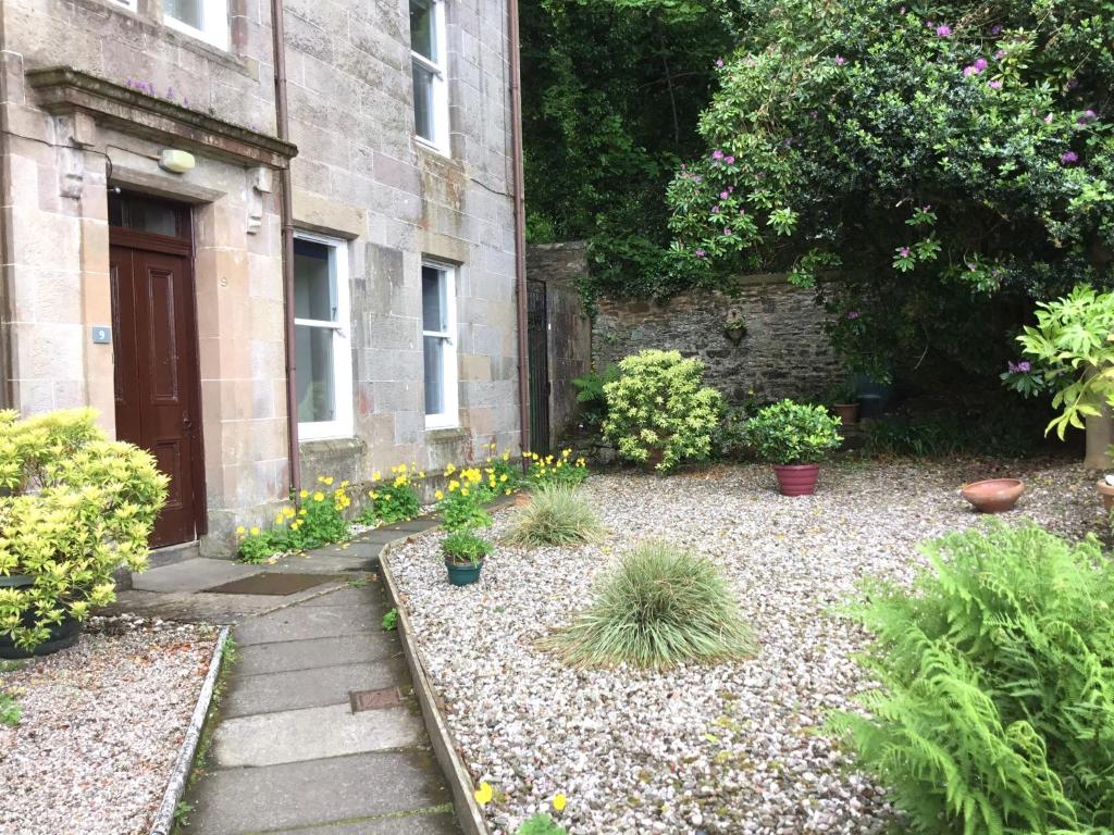 a garden with flowers and plants in front of a building at Chapelhill Hideaway Isle of Bute licence AR00654F in Rothesay