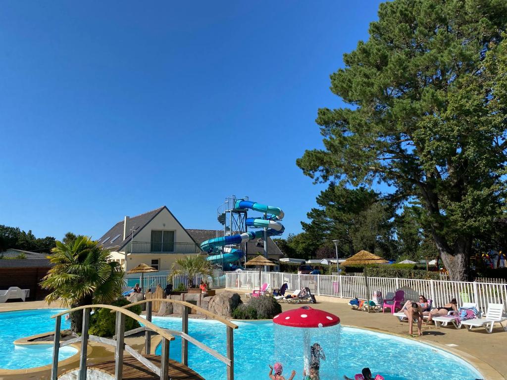 a pool at a water park with a slide at Camping Kost Ar Moor in Fouesnant