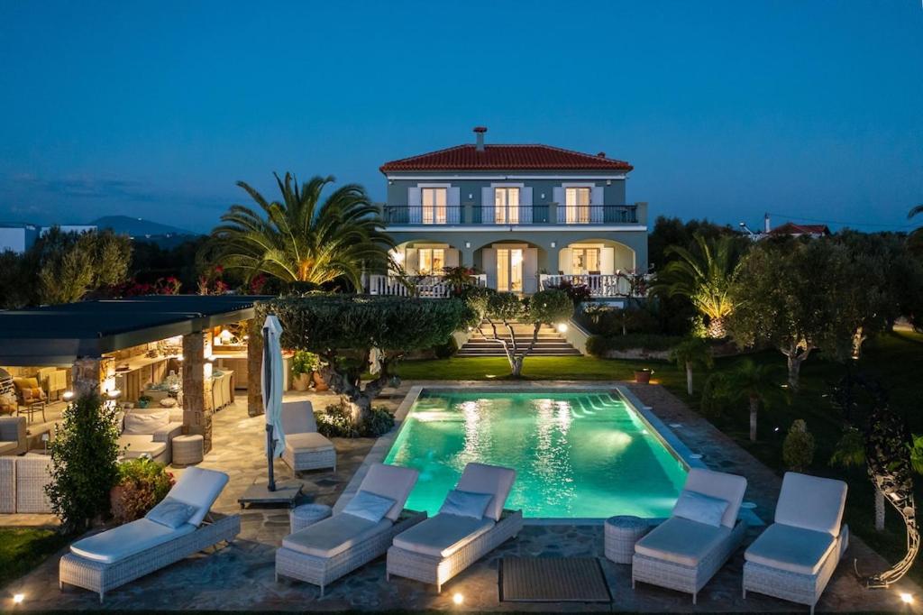 ein Haus mit einem Pool und Liegestühlen in der Unterkunft Luxury Villa Mansion with Extraordinary Sea Views! in Foiníki