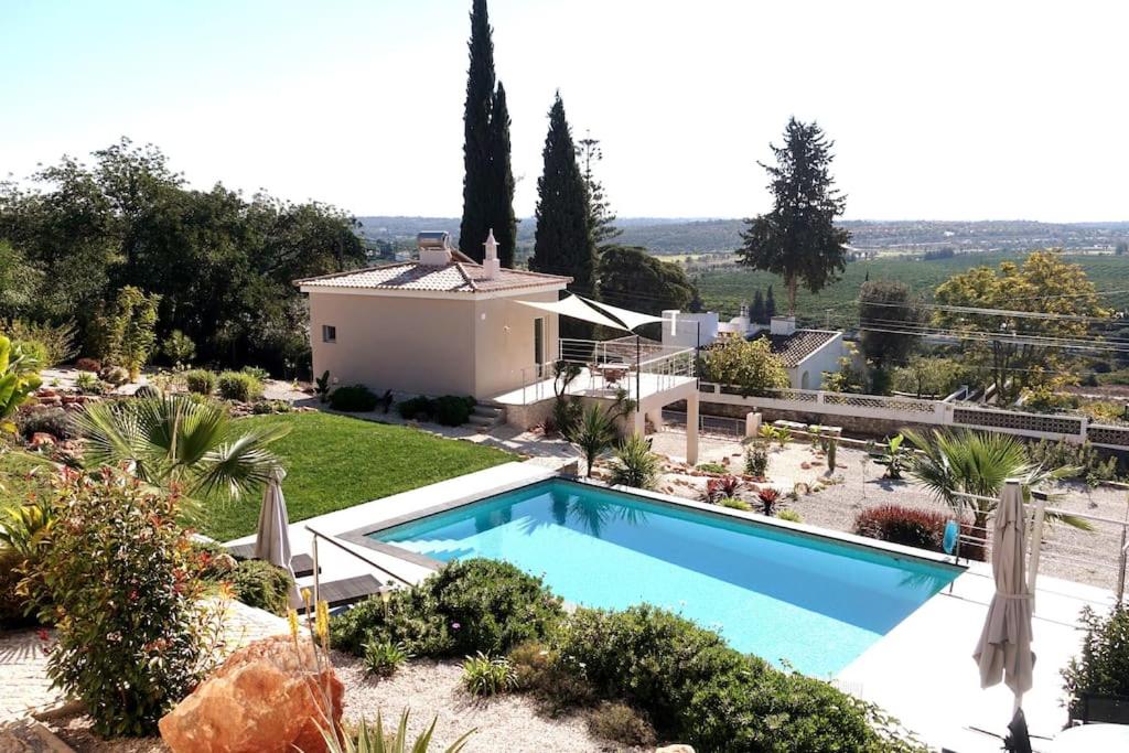 een villa met een zwembad en een huis bij Villa Girassol met zwembad in Alcantarilha