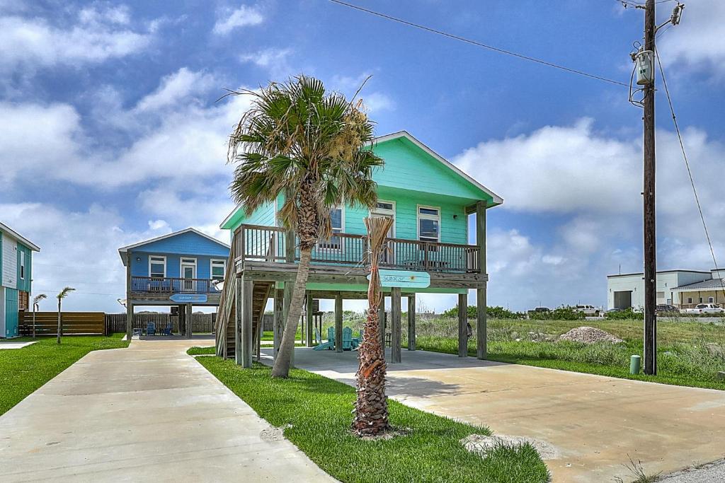 a house with a palm tree in front of it at Eskridge Gem Unit B in Port Aransas