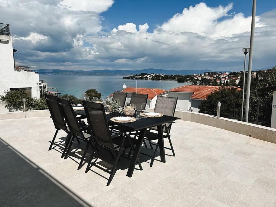 uma mesa preta e cadeiras num pátio com vista para a água em Apartment ”Sand” on island Šolta em Nečujam