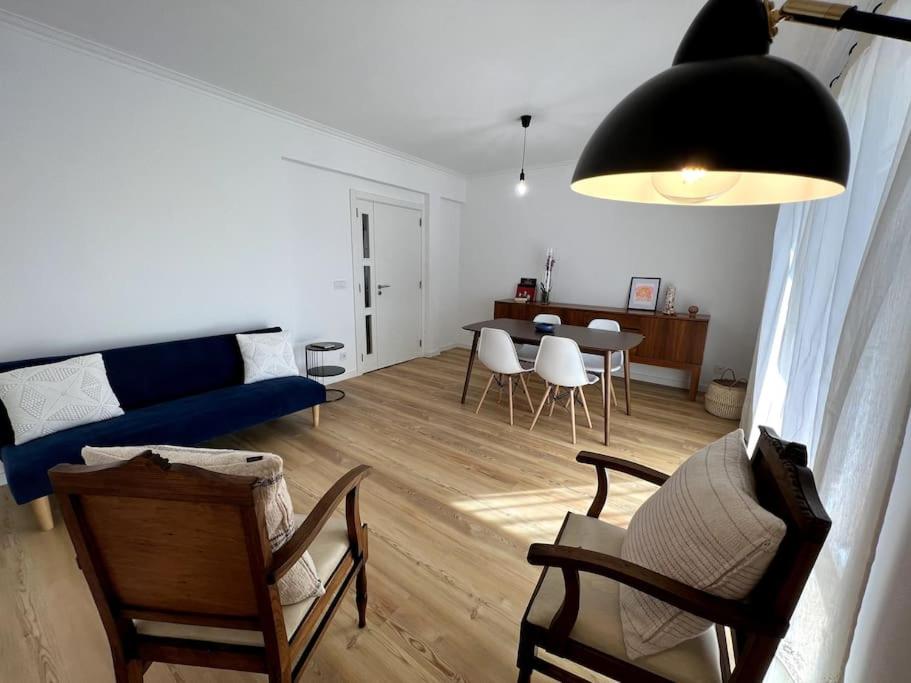 een woonkamer met een bank, stoelen en een tafel bij Ambiente moderno com bom gosto in Coimbra