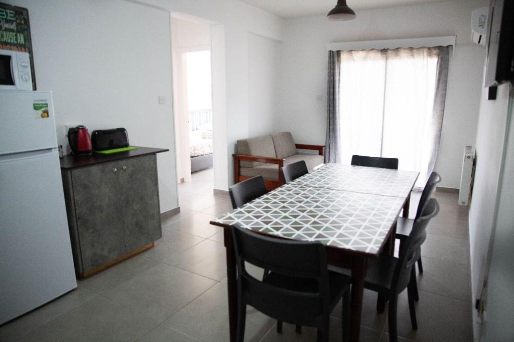 a kitchen and dining room with a table and a refrigerator at Olive Island in Larnaka