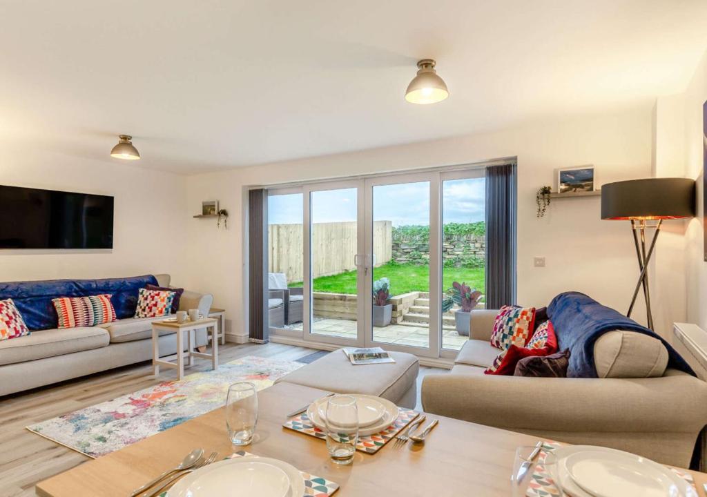 a living room with a couch and a table at Buttercup Cottage in Saint Ervan