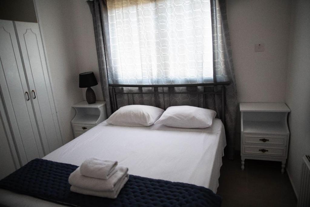 a bedroom with a bed with two towels on it at Olive Island in Larnaka