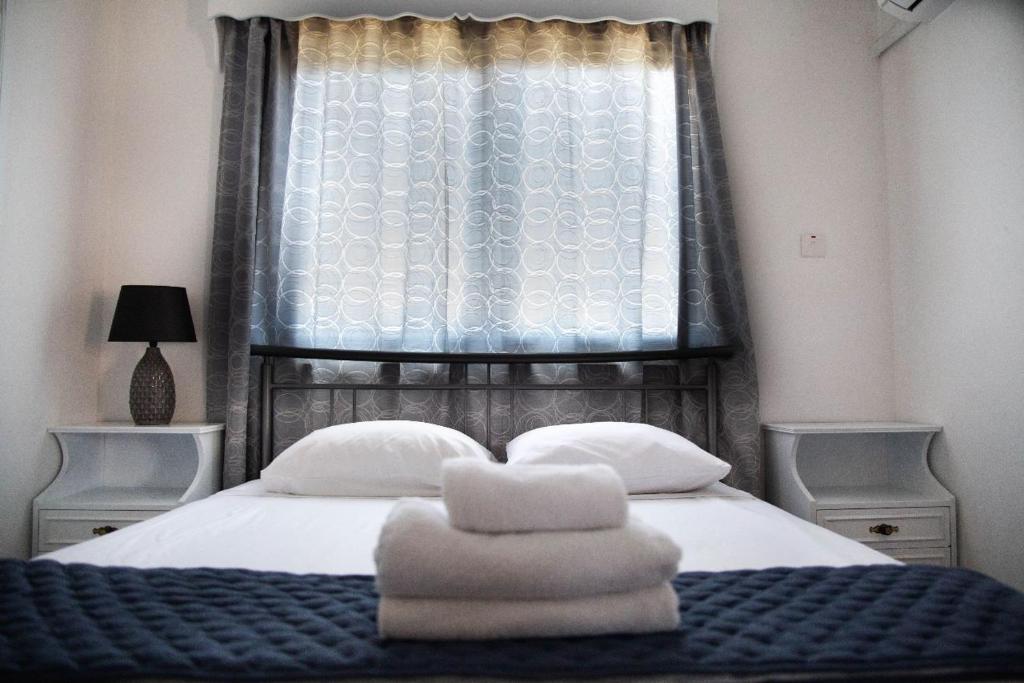 a bedroom with a bed with towels on it at Olive Island in Larnaka