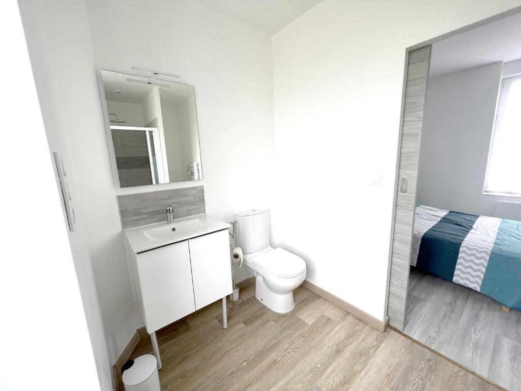 a bathroom with a sink and a toilet and a bed at 180A - Duplex T2 Tout Confort du Gond - 45 m2 in Le Gond-Pontouvre