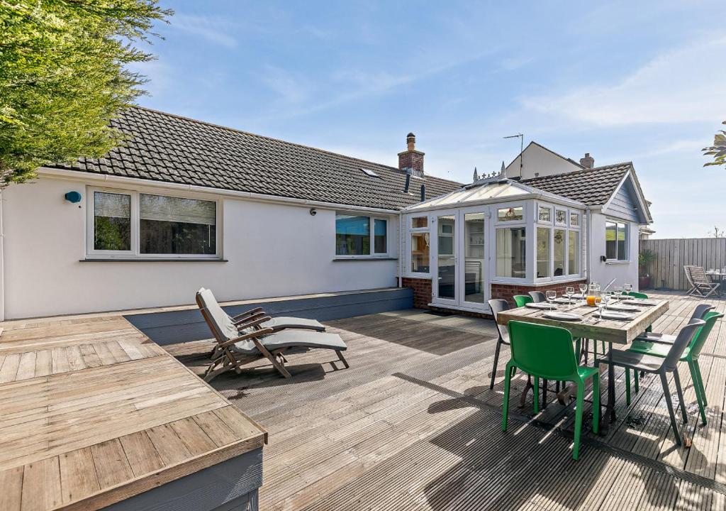 a deck with a table and chairs on a house at The Beach House - Porthcurno in Saint Levan