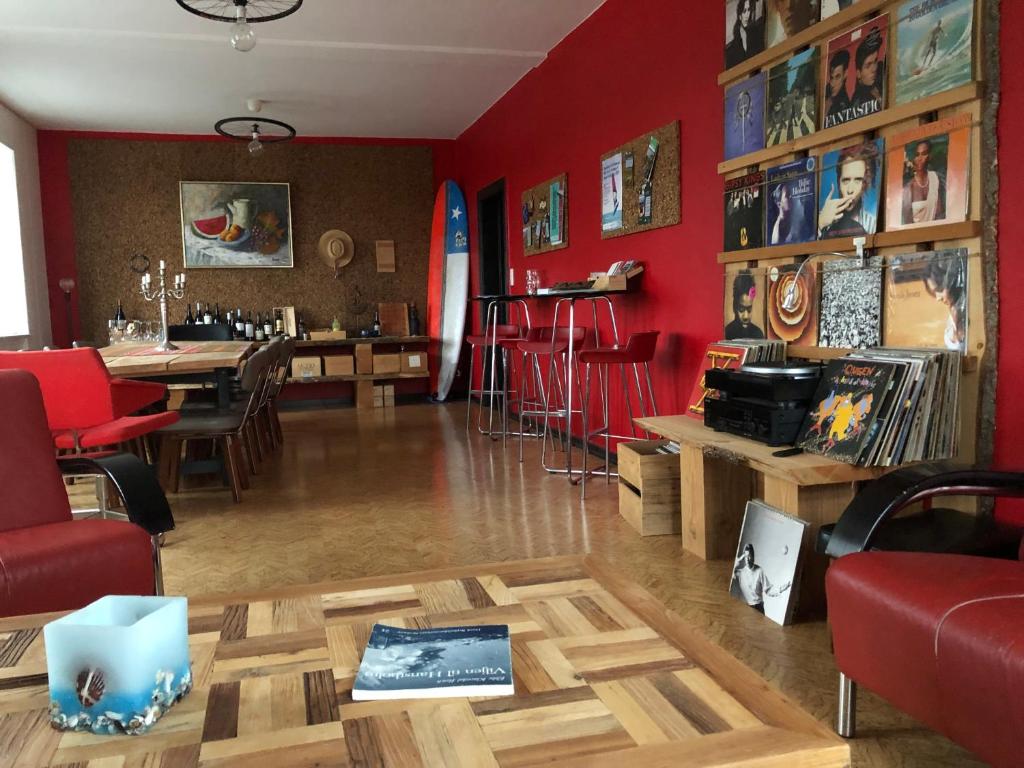 a living room with red walls and a table and chairs at La Ola in Hanstholm