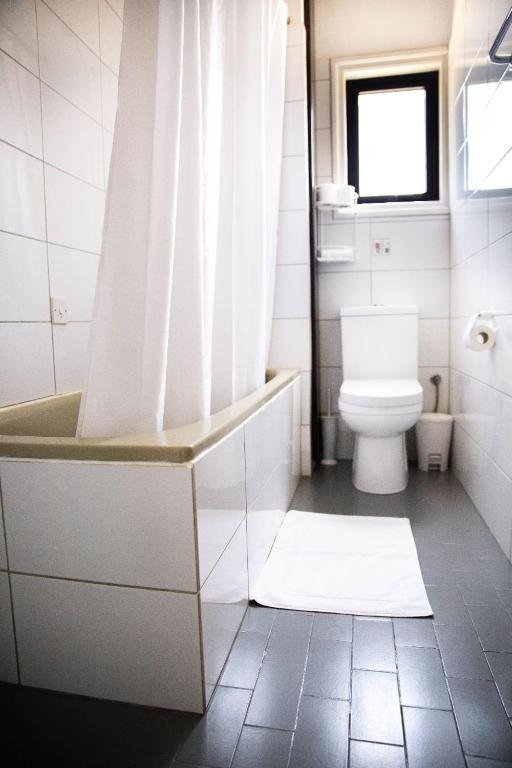 a bathroom with a tub and a toilet and a shower at Olive Island in Larnaka