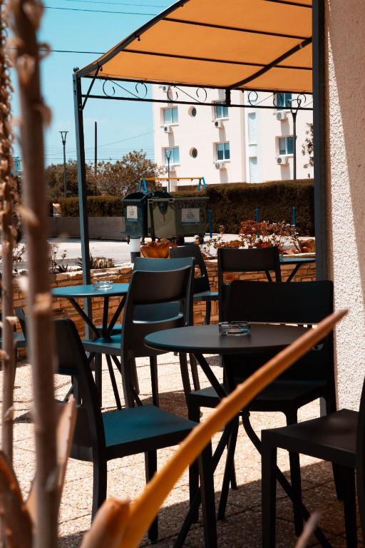 a patio with tables and chairs with an umbrella at Olive Island in Larnaka