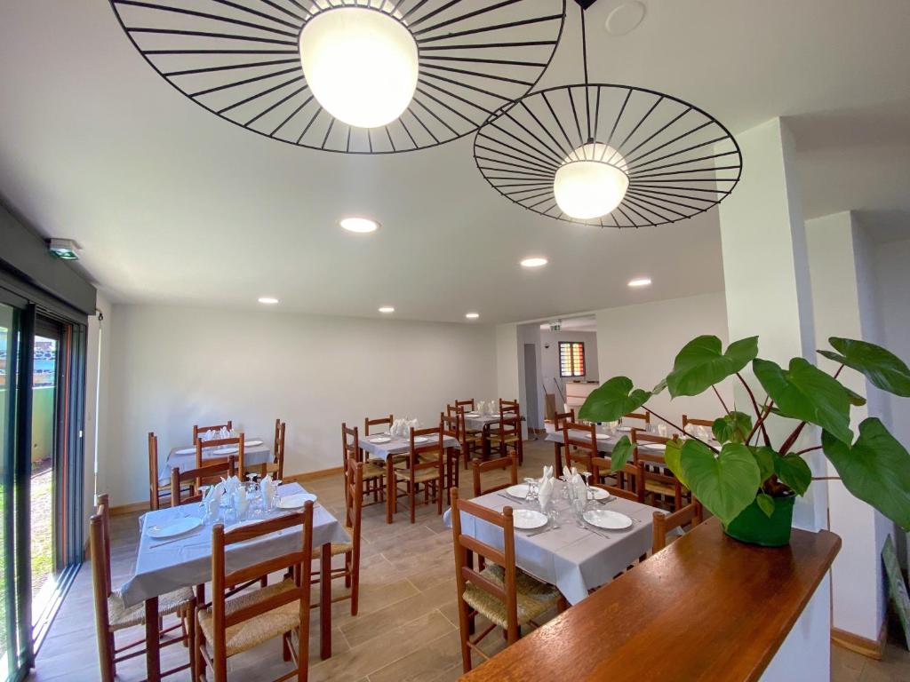 錫拉奧的住宿－Gîte le Fouquet，一间带桌椅和两个吊灯的用餐室