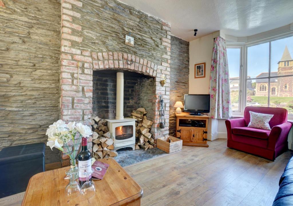 - un salon avec un mur en pierre et une cheminée dans l'établissement Seaview Cottage, à Mortehoe