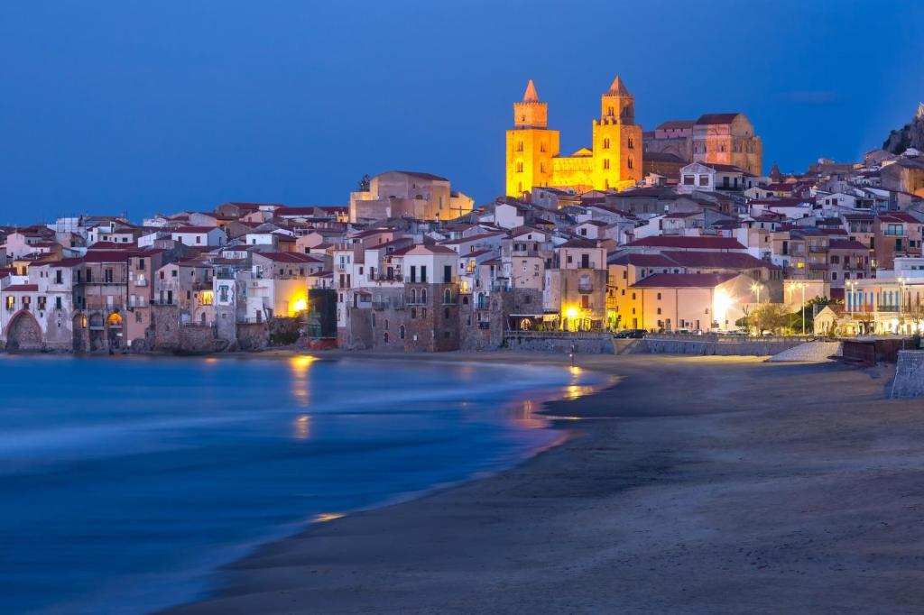 una vista di una città con una spiaggia di notte di Cefalù in Summer a Cefalù