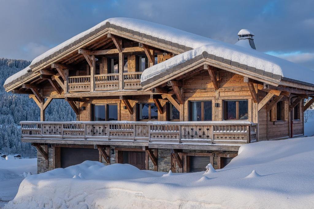 a log cabin with a snow covered roof at Chalet de l'Atray in Les Gets