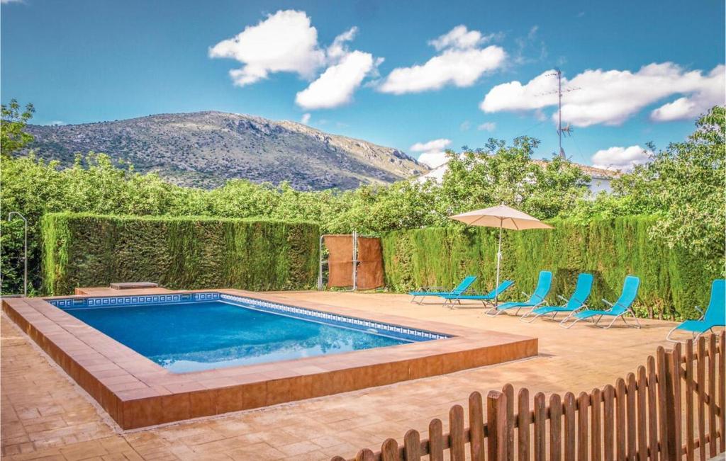 una piscina con sillas y sombrilla en 5 bedrooms villa with private pool furnished terrace and wifi at Priego de Cordoba en Priego de Córdoba