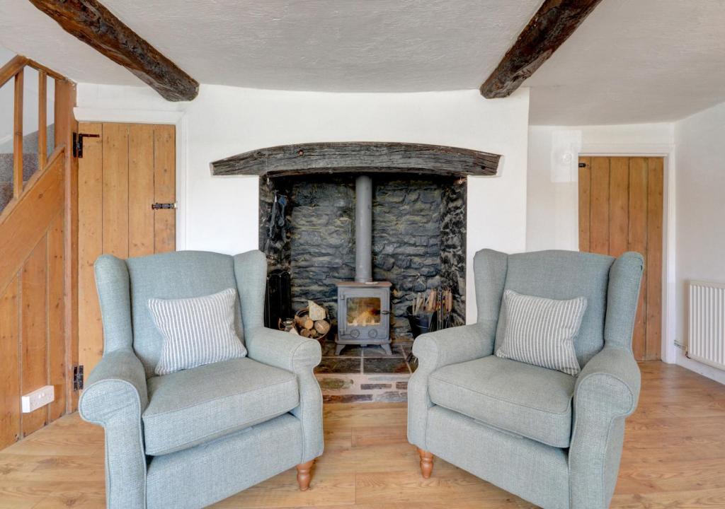 two chairs in a living room with a fireplace at Sunnymead in Barnstaple