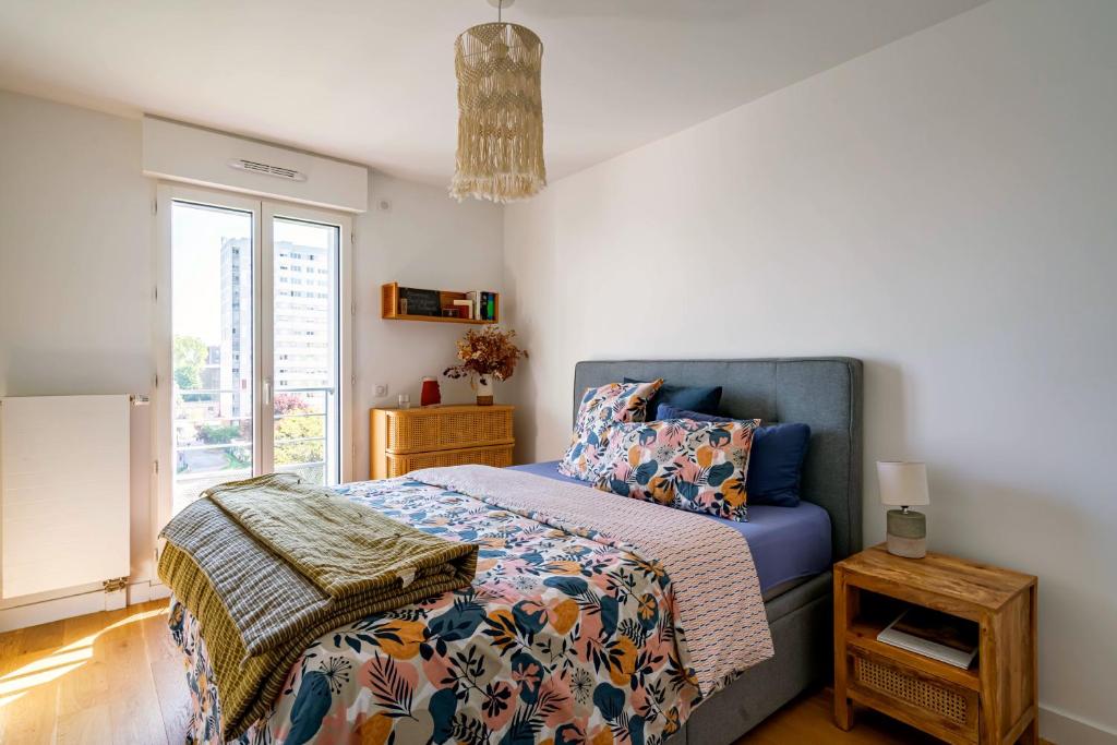 1 dormitorio con 1 cama con edredón azul y ventana en Stunning private room to visit Paris en París