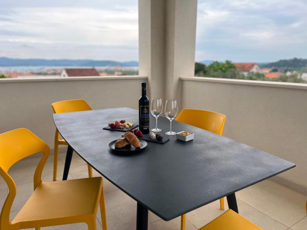 a table with a bottle of wine and wine glasses at Luxury apartment Mon Soleil in Murter